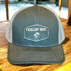 Feelin' Irie Trucker Hat Richardson Hat Color: Black / Graphite Leather Color: Black / Gold 60/40 cotton/polyester 95/5 polyester stretch/spandex mesh back Structured, six-panel, mid-profile Pre-curved contrast stitched visor Comfort stretch R-Flex sweatband Adjustable snapback closure Not recommended for machine wash Fitted Six-panel Trucker Hat For Sports, Fitted Trucker Hat Snapback Style, Fitted Trucker Baseball Cap With Flat Brim, Fitted Trucker Baseball Cap With Curved Bill, Fitted Black Trucker Hat, Black Fitted Trucker Hat, Fitted Trucker Hat With Flat Brim, Fitted Trucker Hat With Curved Bill, Fitted Trucker Hat For Outdoor