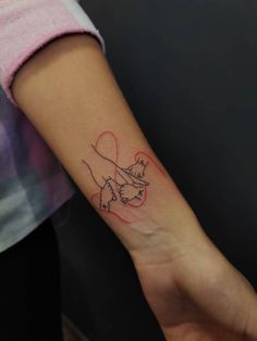 a woman's arm with a dog and heart tattoo on the left side of her arm