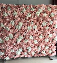 pink and white flowers are arranged on the wall