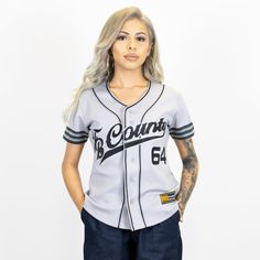 a woman in a baseball uniform poses for the camera with her hands on her hips