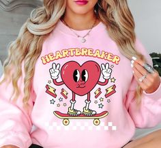 Retro Heartbreaker (2) Sweatshirt | Unisex Comfortable Pullover for Cool Weather | Unique Gifts for Family Friends   Indulge in the spirit of love and fashion with our exclusive Happy Valentine's Day crewnecks! Curated with passion and crafted for comfort, these crewnecks blend heartfelt designs with premium quality, ensuring you celebrate in style. Embrace the essence of romance and joy with each piece, perfect for cozy gatherings or expressing your affection in a chic, casual style.    Key Features: High-Quality Material: Made from soft and durable fabric, this sweatshirt is built to last and keep you warm throughout the season. Unisex Design: This versatile pullover suits all genders, offering a relaxed and comfortable fit. Charming Appeal: Our cute fall sweatshirt is designed to add a Long Sleeve T-shirt With Heart Graphic For Streetwear, Long Sleeve Sweatshirt With Heart Graphic For Streetwear, Heart Graphic Crew Neck Sweatshirt For Streetwear, Pink Casual Sweatshirt With Heart Graphic, Trendy Heart Graphic Sweatshirt For Winter, Casual Pink Sweatshirt With Heart Graphic, Trendy Winter Sweatshirt With Heart Graphic, Trendy Heart Graphic Sweatshirt For Fall, Trendy Fall Sweatshirt With Heart Graphic