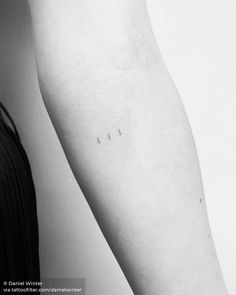 a woman's arm with three small tattoos on it