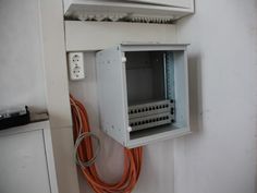 an electrical box mounted to the side of a wall with wires and plugs in it