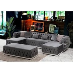 a large gray couch sitting on top of a floor next to a chair and ottoman