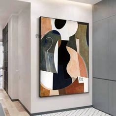 an abstract painting hangs on the wall next to a tiled floor in a large room