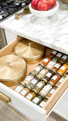 an open drawer in a kitchen filled with spices