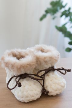 a pair of white slippers sitting on top of a wooden table