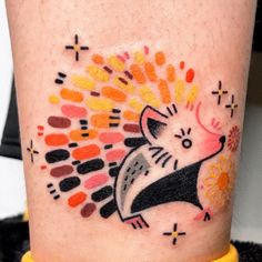 a colorful tattoo on the leg of a person with an animal in it's head