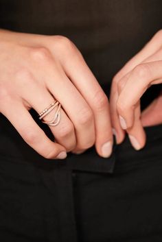 a woman's hands with two rings on her fingers and one ring in the other hand