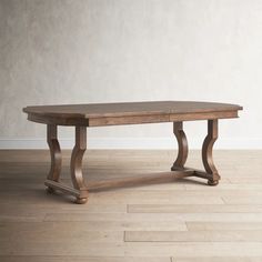 a wooden table sitting on top of a hard wood floor next to a white wall