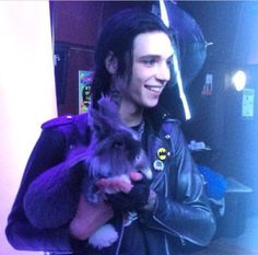 a man in a leather jacket holding a cat