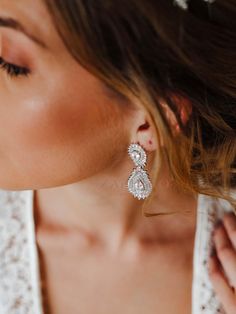 a woman wearing a pair of diamond earrings