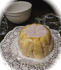 a loaf of bread sitting on top of a white doily next to a bowl