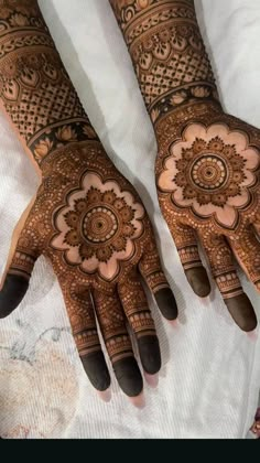 two hands with henna designs on them