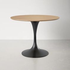 an oval wooden table sitting on top of a white floor