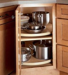 an open cabinet with pots and pans in it