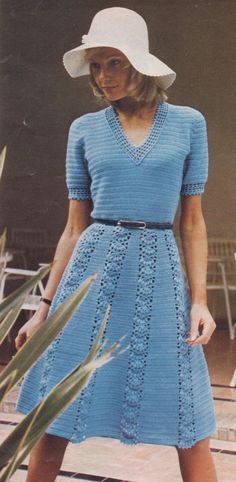 a woman in a blue dress and white hat