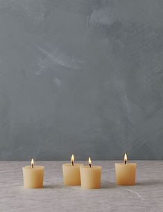 four candles are lined up in front of a chalkboard