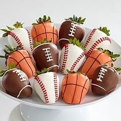 chocolate covered strawberries with football decorations on them in a white bowl, ready to be eaten