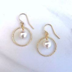 "These classic earrings are made with large white pearls dangling inside a delicate gold/ silver circle.   The hoops are lightly textured to add a bit of extra sparkle.  Lightweight and dangling.   A timeliness keepsake that never goes out of fashion.  The perfect accessory for work, dress-up, or everyday look.  SPECIAL FEATURE: - 1.5\" from the top curve of the earwire to the base of the earring.  - All components are 14K gold-filled or sterling silver.  Suitable for sensitive skin.  - 8mm Swar Single Pearl Earrings, Pearl Gifts, Earrings Classic, Single Pearl, Geode Earrings, Bar Stud Earrings, Earrings Diy, Classic Earrings, Etsy Bridesmaid Gifts