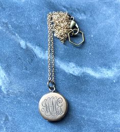 "This necklace was handmade using a combination of new and antique materials. It features an antique small round gold-filled locket that has one blank side and one side engraved with the initials MMcG. It is on a new gold-filled chain that is finished with an antiqued brass (over copper) lobster clasp and a brass hexagon loop. The locket measures .75\" tall and .75\" across. The chain is 18\" long. Condition: Minor surface scuffs consistent with age." Brass Medallion Charm Necklaces, Engraved Medallion Brass Charm Necklaces, Engraved Brass Medallion Charm Necklaces, Engraved Medallion Charm Necklace In Brass, Antique Gold Medallion Necklace For Gift, Engraved Brass Medallion Charm Necklace, Classic Personalized Medallion Jewelry, Classic Rose Gold Brass Jewelry, Elegant Brass Charm Necklace With Locket