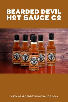 three bottles of bearded devil hot sauce on a table with the title bearded devil hot sauce co