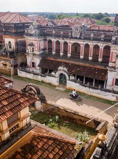 an aerial view of old buildings and courtyards in a city with red tile roofs