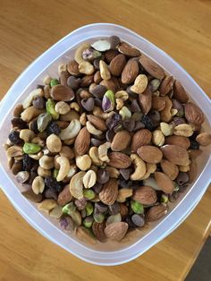 a bowl filled with nuts on top of a wooden table