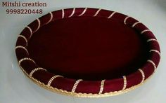 a red and gold basket sitting on top of a white table next to a wall