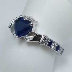 Claddagh Heart Blue Sapphire and diamonds Ring In 14K White Gold, Irish Celtic Band Center Stone: Shape: Heart Shape Carat Weight: Approx. 0.96 Color, Clarity: Medium Blue, Eye Clean Measurements: Approx. 6 x 6mm Side Stones Shape: Round Cut Diamonds & Sapphires Color, Clarity: G-H, VS-SI 100% natural diamonds & Medum Blue, Eye Clean (sapphires) Carat Weight: 0.10ct + 0.06 = 0.16ct Setting Metal: 14K White Gold Ring Size: 6.25; Free sizing from 4-8 Return Policy: 100% satisfaction guaran Heart-shaped Sapphire Jewelry For Anniversary, Heart Cut Sapphire Gemstone Jewelry, Heart Shaped Sapphire Rings For Formal Occasions, Sapphire Heart Cut Jewelry With Brilliant Detail, Heart-shaped Sapphire Jewelry With Brilliant Cut, Heart-cut Sapphire Jewelry With Brilliant Cut, Formal Sapphire Heart-shaped Rings, Luxury Sapphire Heart Cut Jewelry, Heart Cut Sapphire Jewelry With Brilliant Cut