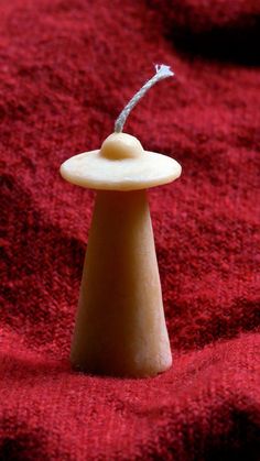 a small white object sitting on top of a red blanket