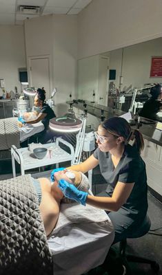 a woman getting her leg examined by a doctor in a room full of medical equipment