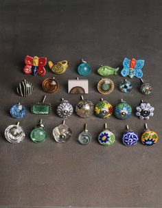 there are many different items on the floor next to each other, including brooches and pendants