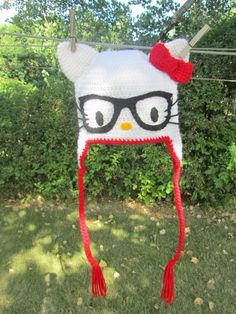 a knitted hat with glasses and a cat's head on top of it