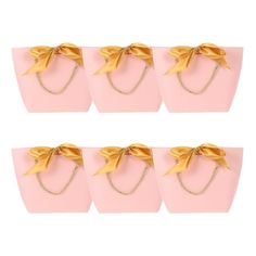 six pink bags with gold bows on them