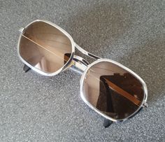 Awesome 1980s metal sunglasses, maybe late 1970s. I love the geometrical and silver metal frame, totally matching the era. It says 'MARA' on the inside. In very good vintage condition, minor signs of use. Width: 13 cm / 5.1 in.  Dimensions glasses including the frame about 4.25 x 5.5 cm / 1.75 x 2.15 in Please note: only the glasses as shown, no extras and no box. Retro Metal Sunglasses With Mirrored Lenses, Retro Metal Sunglasses With Gradient Lenses, Retro Metal Sunglasses With Tinted Lenses, Retro Tinted Metal Sunglasses, Vintage Metal Sunglasses With Gradient Lenses, Vintage Silver Sunglasses With Metal Frame, Retro Silver Metal Sunglasses, Retro Silver Sunglasses With Metal Frame, Vintage Metal Sunglasses With Tinted Lenses