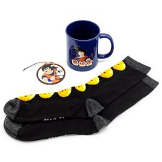 a pair of mickey mouse socks next to a coffee mug and coaster on a white background