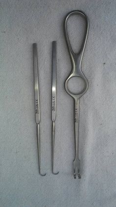 a pair of scissors and tongs sitting next to each other