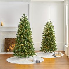 two small christmas trees are sitting on the floor