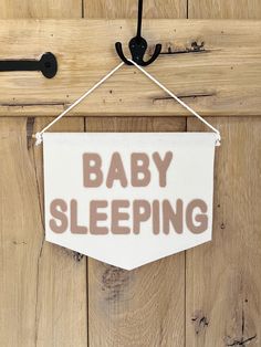 a baby sleeping sign hanging on a wooden door