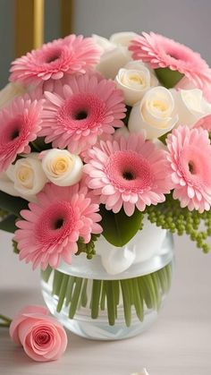 a vase filled with pink and white flowers on top of a table next to a pair of scissors