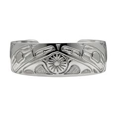 This is a wide  hand engraved cuff bracelet showing two Ravens with a Sun in the center,  created by the Haida Gwaii artist Robert Cross.  It is done in Sterling Silver, is 3/4 inches wide or about 2 cm and the silver band is about 6 inches in length with a gap of 0.75 inches in the back.  Its is adjustable.  This is a beautiful piece with a balance of fine detail and deep strong engraved lines all done by hand. Raven The creator, transformer, and trickster. He is mischievous and playful, symbol Symbolic Stamped Cuff Bracelet, Symbolic Engraved Cuff Bangle Bracelet, Engraved Wide Band Bangle As Gift, Wide Band Engraved Bangle Gift, Symbolic Engraved Ceremonial Cuff Bracelet, Symbolic Sterling Silver Cuff Bracelet, Symbolic Engraved Cuff Bracelet For Ceremonies, Ceremonial Bangle Cuff Bracelet With Polished Finish, Ceremonial Polished Cuff Bangle Bracelet