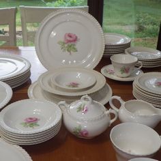 a table topped with lots of white dishes and cups