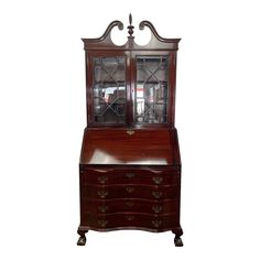 an antique wooden desk with glass doors and drawers