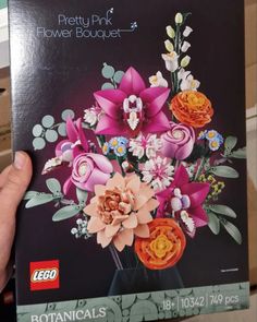 a person holding up a box with flowers in it's front and back sides