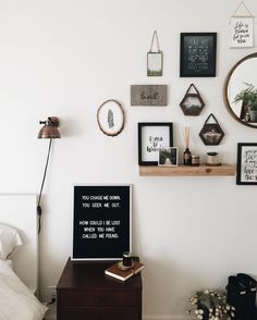 a bedroom with white walls and various framed pictures on the wall, along with a bed