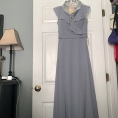 a dress hanging on a door with a lamp next to it