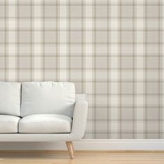 a white couch sitting in front of a wall with a checkered pattern on it