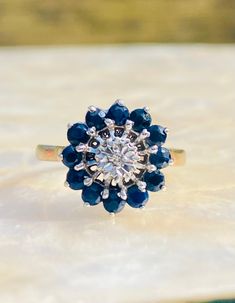 a diamond and blue sapphire ring sitting on top of a table