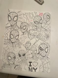 a drawing of spiderman faces on a piece of paper with the word i love ny